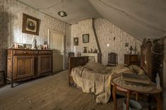 an old fashioned bedroom with wooden floors and walls