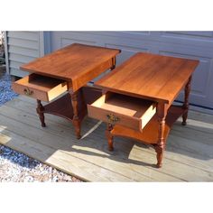 two wooden tables sitting on top of a wooden floor next to a garage door and gravel area