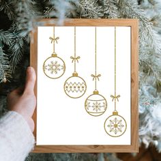 someone holding up a card with ornaments hanging from it