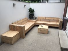 a wooden bench sitting on top of a patio next to a potted planter