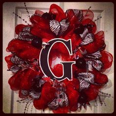 a red wreath with the letter c on it