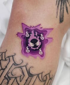 a close up of a person's arm with tattoos on it and an animal in the center