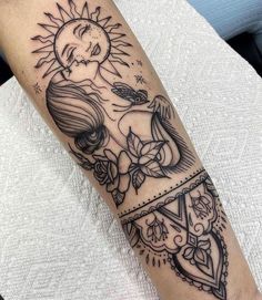 a black and white tattoo on the arm of a woman with sun, moon and flowers