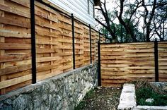 a wooden fence next to a stone wall