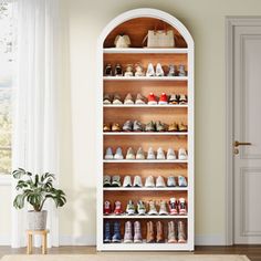 a white shoe rack filled with lots of shoes next to a door in a room