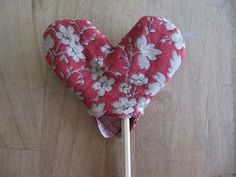 a heart shaped lollipop sitting on top of a wooden table