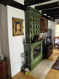 an old fashioned green cabinet in the middle of a living room with hardwood floors and white walls