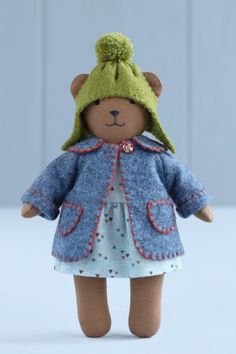 a teddy bear wearing a blue coat and hat