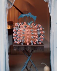 a table with an umbrella on top of it in front of a window and curtains