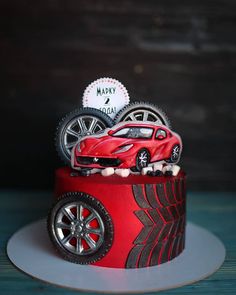 a red car cake with wheels on top