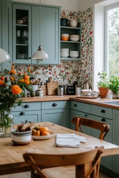 a kitchen filled with lots of wooden furniture and flowers on the counter top next to a window