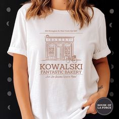 "\"Kowalski Fantastic Bakery\" Adult Shirt :: GARMENT INFO :: - 100% Soft cotton (fibre content may vary for different colors) - The sleeves are rolled up for display purposes only :: SIZING :: - The Unisex sizing makes the shirt run larger than your average t-shirt (for women). We suggest ordering a size smaller than what you would normally wear. The shirts run true to size for men. - Please check out our size chart for measurements to ensure an accurate fit - No exchanges/returns for wrong siz Bakery T Shirt Design, Cookie Brand Shirt, Bakery Tshirt, Bakery Shirts, Food T-shirt, Universal Vacation, Food Shirt, Adulting Shirts, Graphic Shirts