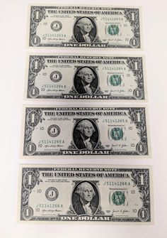 three stacks of one hundred dollar bills sitting on top of each other in front of a white background