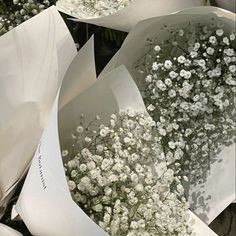 white flowers are wrapped in paper and ready to be used as bouquets or centerpieces