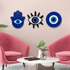 two pink chairs in front of a wall with blue eyes and an eyeball on it