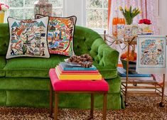 a living room filled with green couches and colorful pillows on top of each other