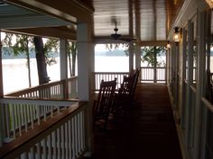 an empty porch with rocking chairs on it