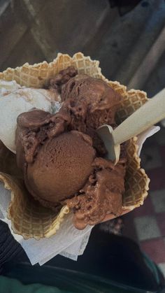 two scoops of chocolate ice cream in a waffle cone