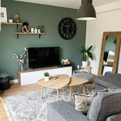 a living room filled with furniture and a flat screen tv mounted on a wall above a wooden coffee table