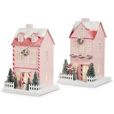 two pink houses with christmas decorations on them