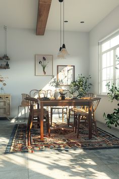 a dining room table and chairs with plants on the rug in front of it, next to a large window