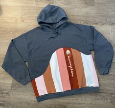 a blue hoodie with an orange and white stripe on the side that says champion