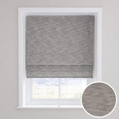 a grey roman blind in front of a window