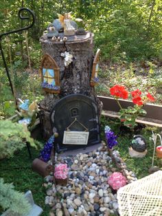 a fairy garden with a tree stump in the middle