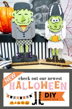 two paper cut out halloween characters sitting on top of a table with pumpkins in the background