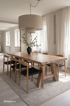 a dining room table and chairs in front of a large window