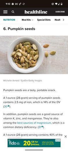 a bowl filled with pumpkin seeds on top of a table