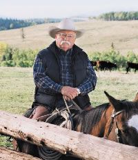 an old man is sitting on a horse in front of some cows and holding the reins