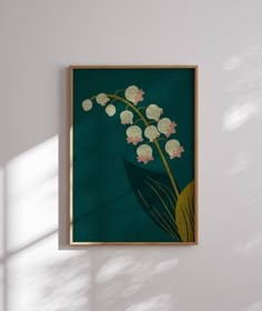 a painting hanging on the wall next to a vase with white flowers and green leaves