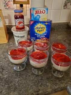 several small bowls filled with food sitting on top of a counter next to a box of jello