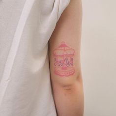 a woman's arm with a pink cake tattoo on the left side of her arm