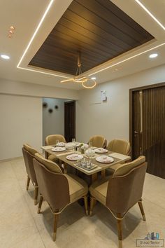 a dining room table set for six with beige chairs and white plates on the table