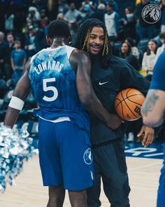 two basketball players hugging each other on the court