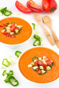 two bowls of tomato soup with chopped vegetables