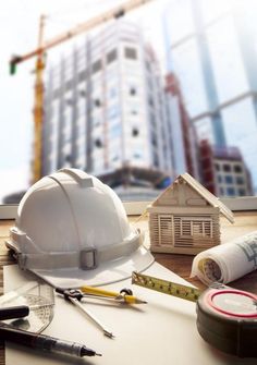 some construction tools are sitting on a table in front of a large building under construction