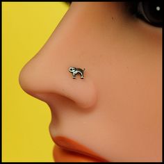 a close up of a person's nose with a small dog pin on it