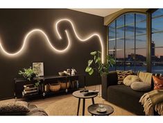 a living room filled with furniture and a large window overlooking the city at night time