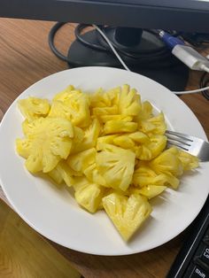 a white plate topped with sliced pineapple next to a computer keyboard