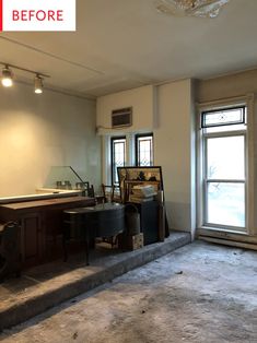 an empty room with two windows and a piano on the floor in front of it