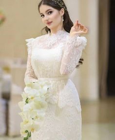 a woman in a white dress holding flowers