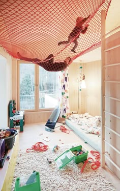 two children are playing in a bedroom with toys and other items on the floor,