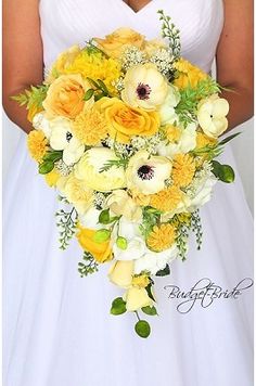 a bride holding a bouquet of yellow and white flowers