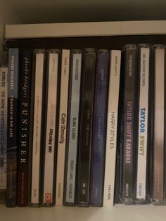 a shelf filled with lots of different types of cd's on top of each other