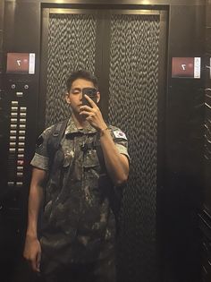 a man taking a selfie in front of lockers with his cell phone up to his face