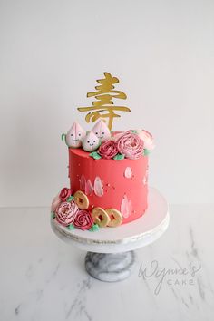 there is a cake with pink flowers on the top and two cats sitting on top