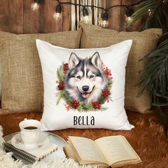 a white pillow with a dog's face on it next to an open book